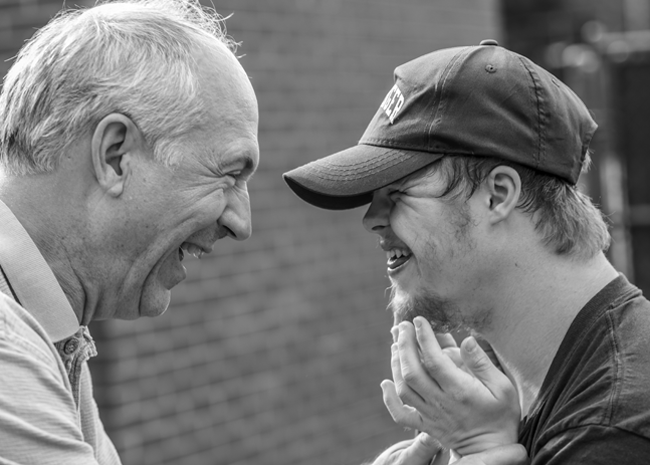 Trusted caregiver laughing with special needs child.